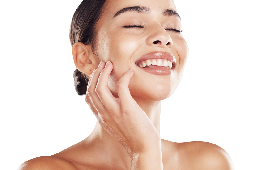 A smiling woman touching her clean, glowing skin